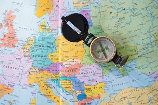 A flat lay image of a compass on a map of Europe, symbolizing travel and direction planning.