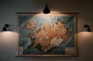 A vintage map of Iceland illuminated by warm lights on a museum wall.